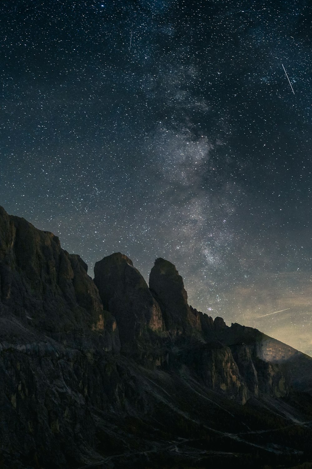 le ciel nocturne avec des étoiles au-dessus d’une chaîne de montagnes