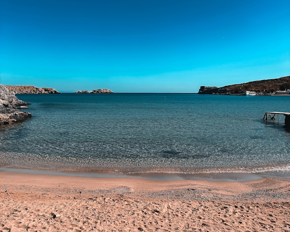 a body of water sitting next to a sandy beach