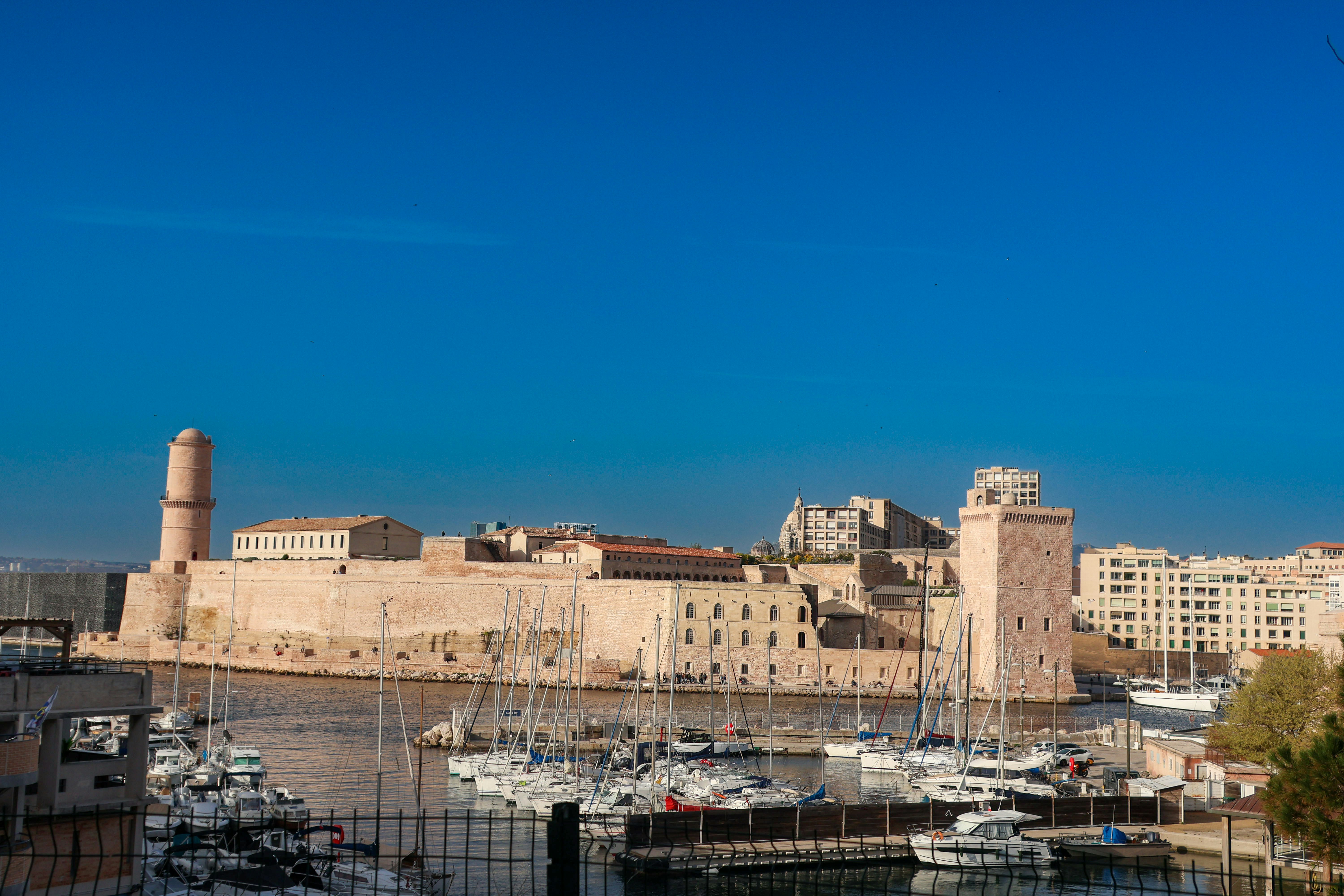a harbor filled with lots of boats next to tall buildings, 