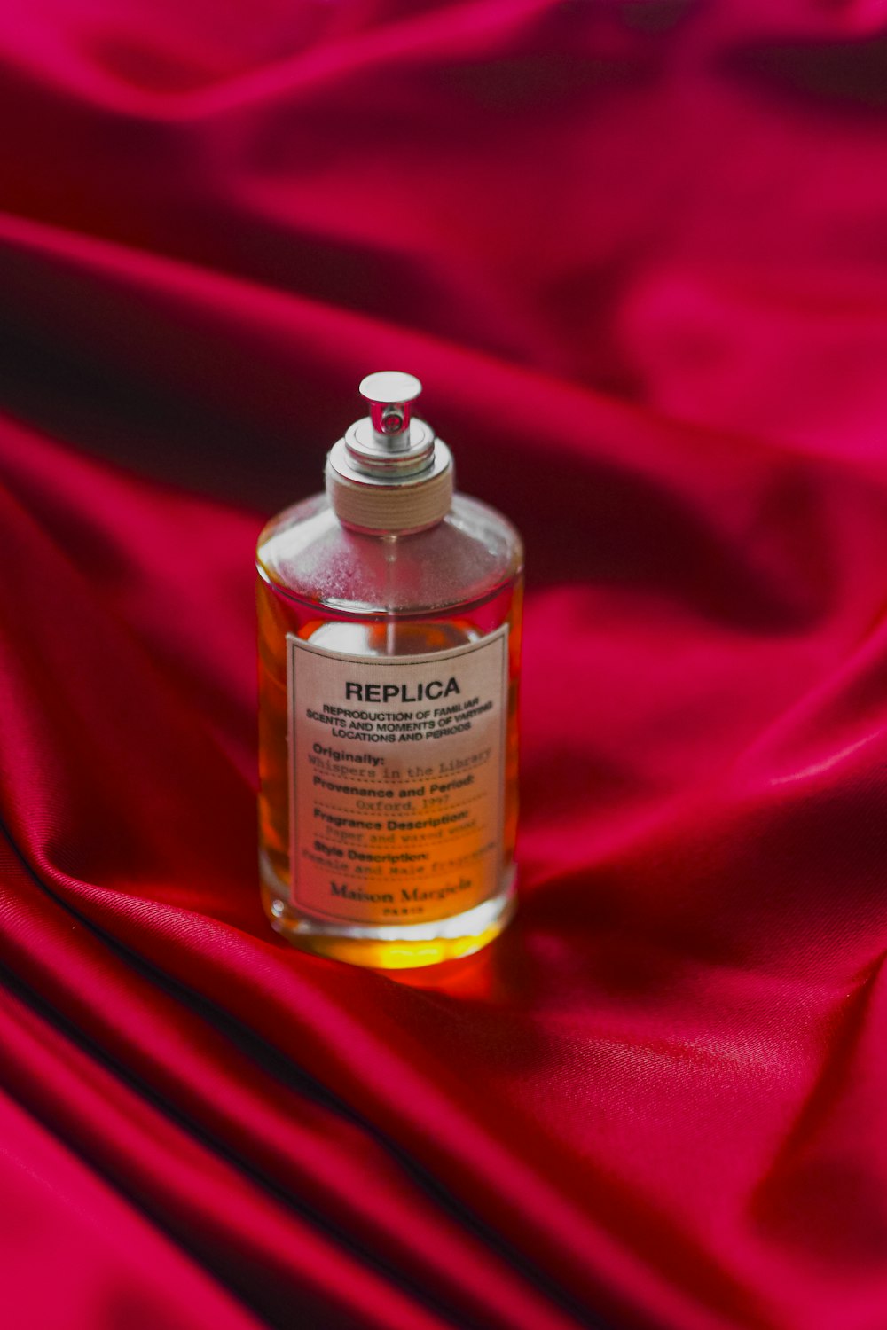 a bottle of perfume sitting on a red cloth
