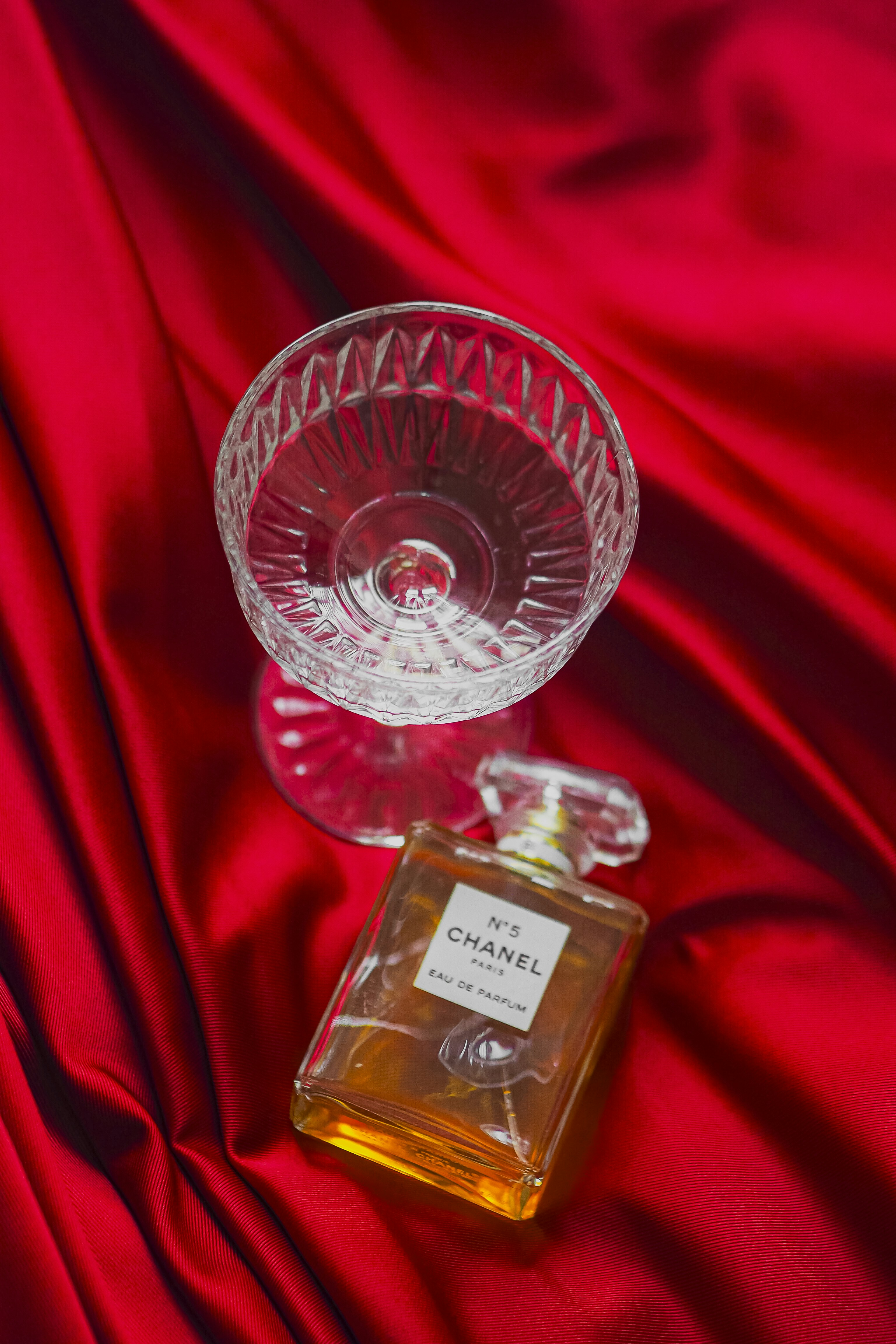 a bottle of perfume sitting on a red cloth