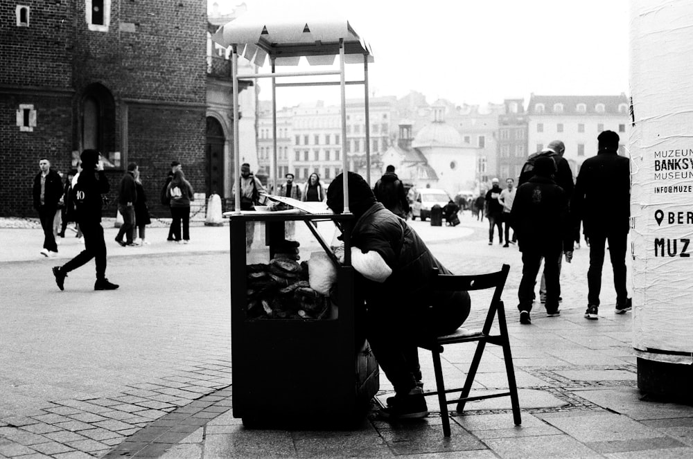 a man sitting at a table on a sidewalk