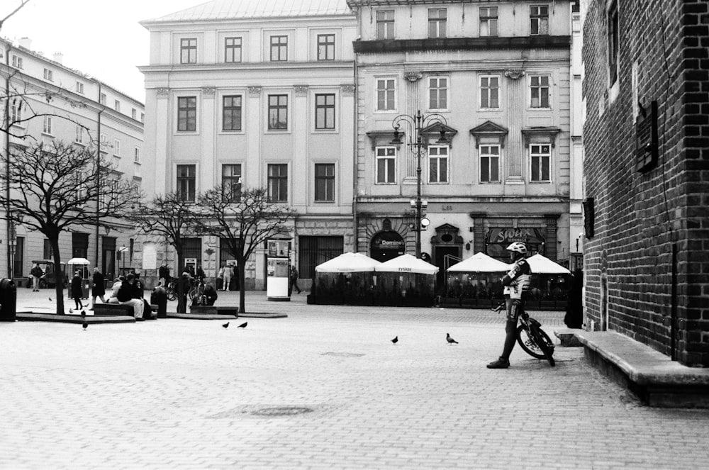 a black and white photo of a person on a bike