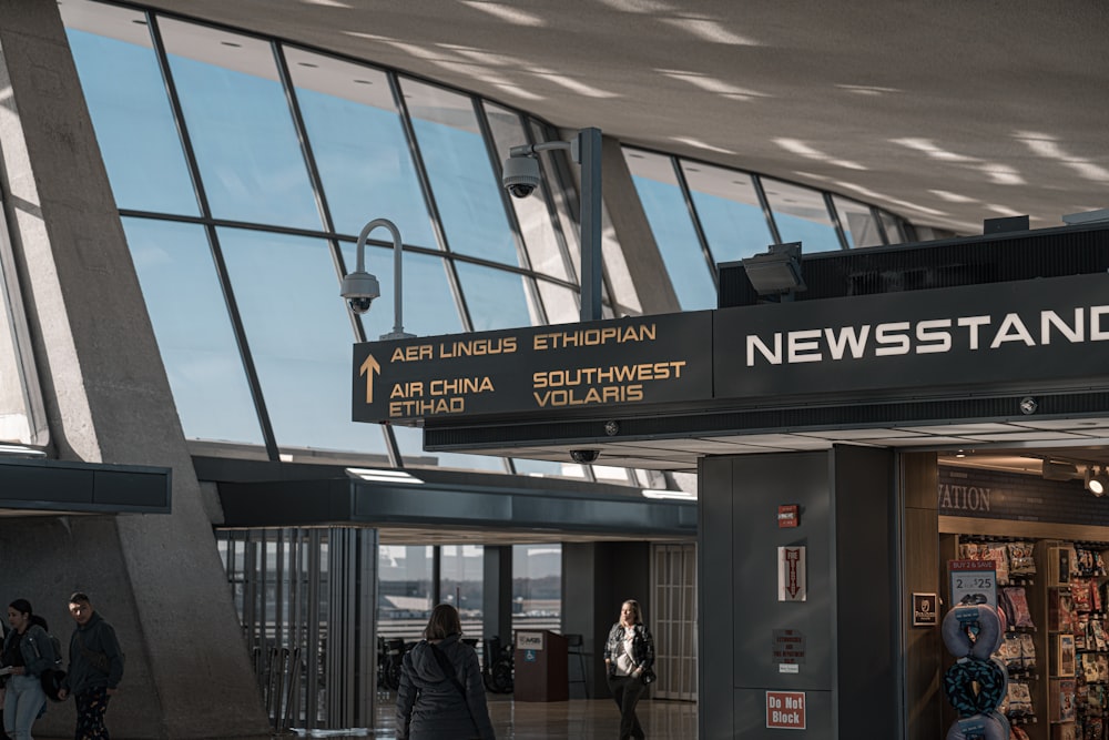 people are walking through the lobby of an airport