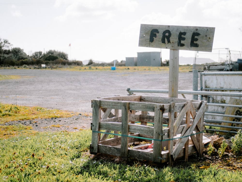 a wooden crate sitting in the grass next to a sign