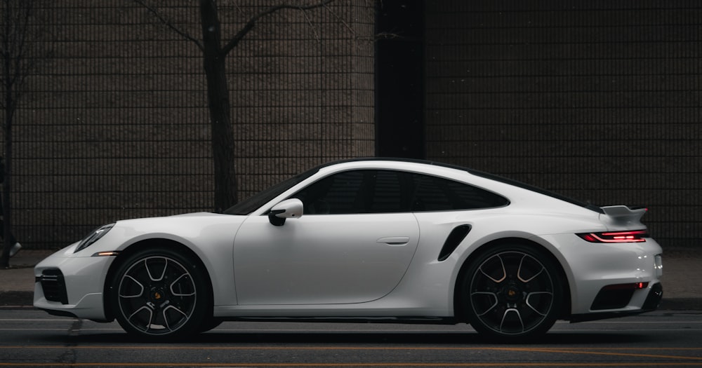 a white sports car parked in front of a building