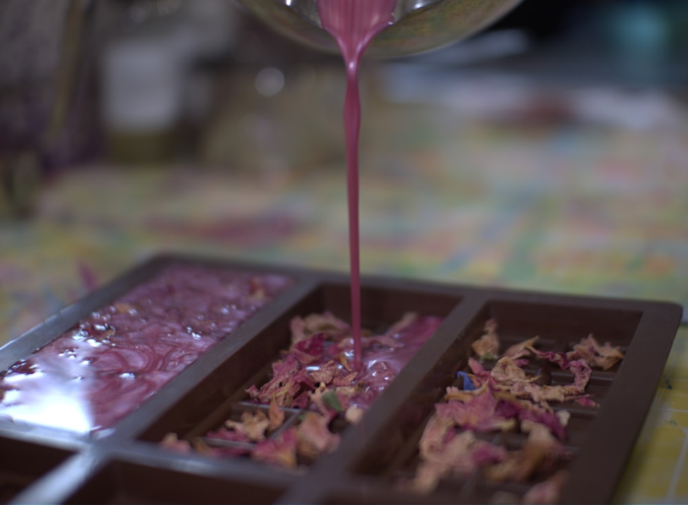 a pink substance is being poured into a tray