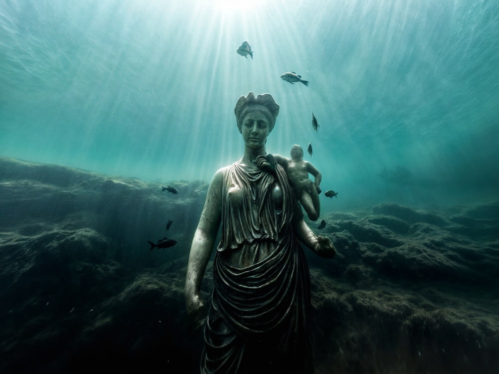 a statue of a woman holding a baby under water