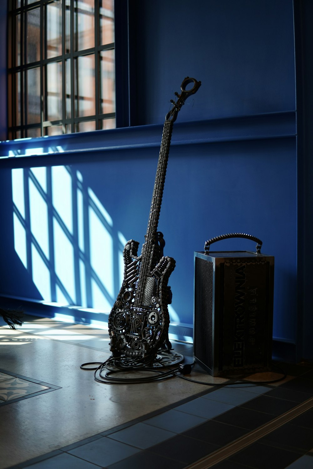 a guitar sitting on the ground next to a suitcase