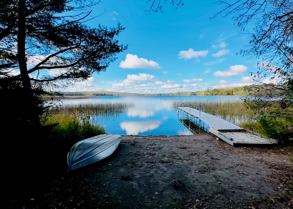 a boat sitting on the shore of a lake