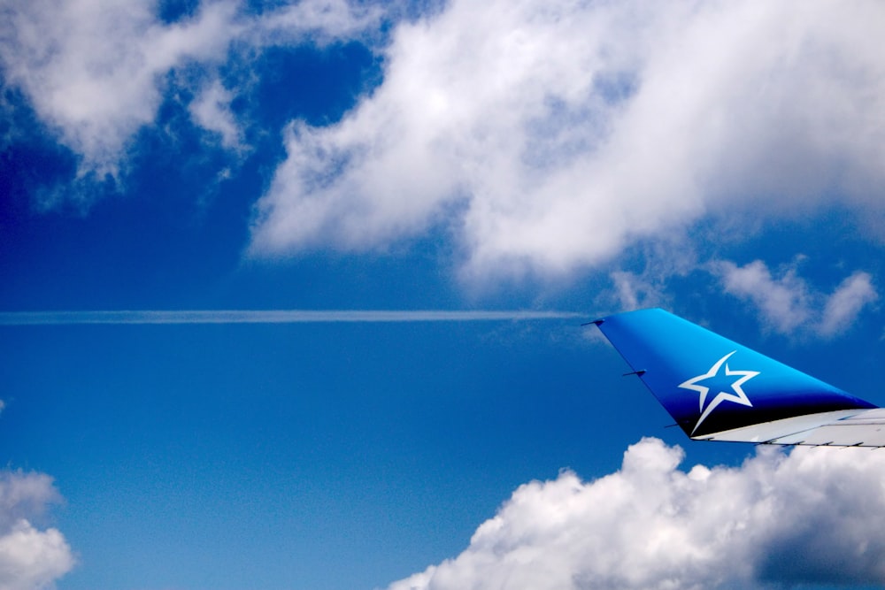 un avion volant dans le ciel avec une étoile blanche sur la queue