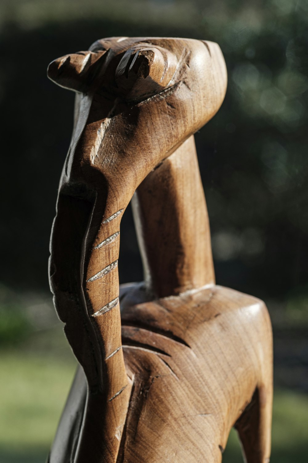 uma estátua de madeira de uma pessoa com uma mão na cabeça