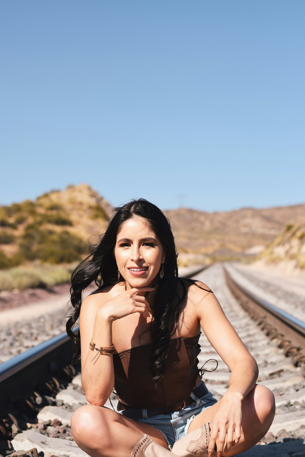 a woman sitting on a train track posing for a picture