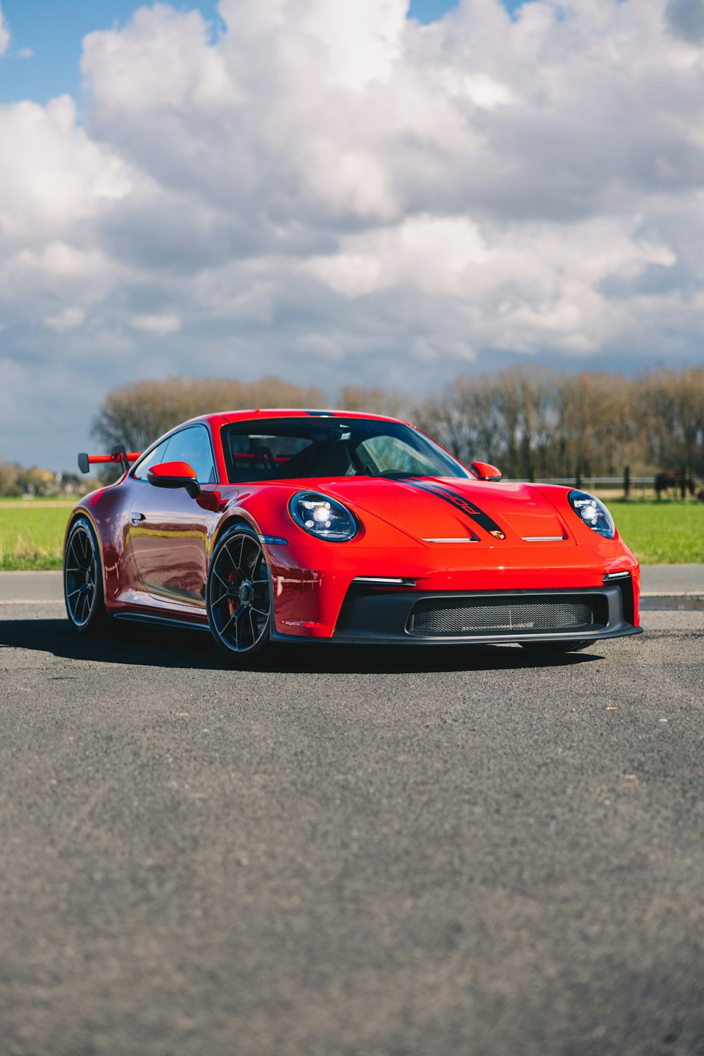 a red sports car driving down a road