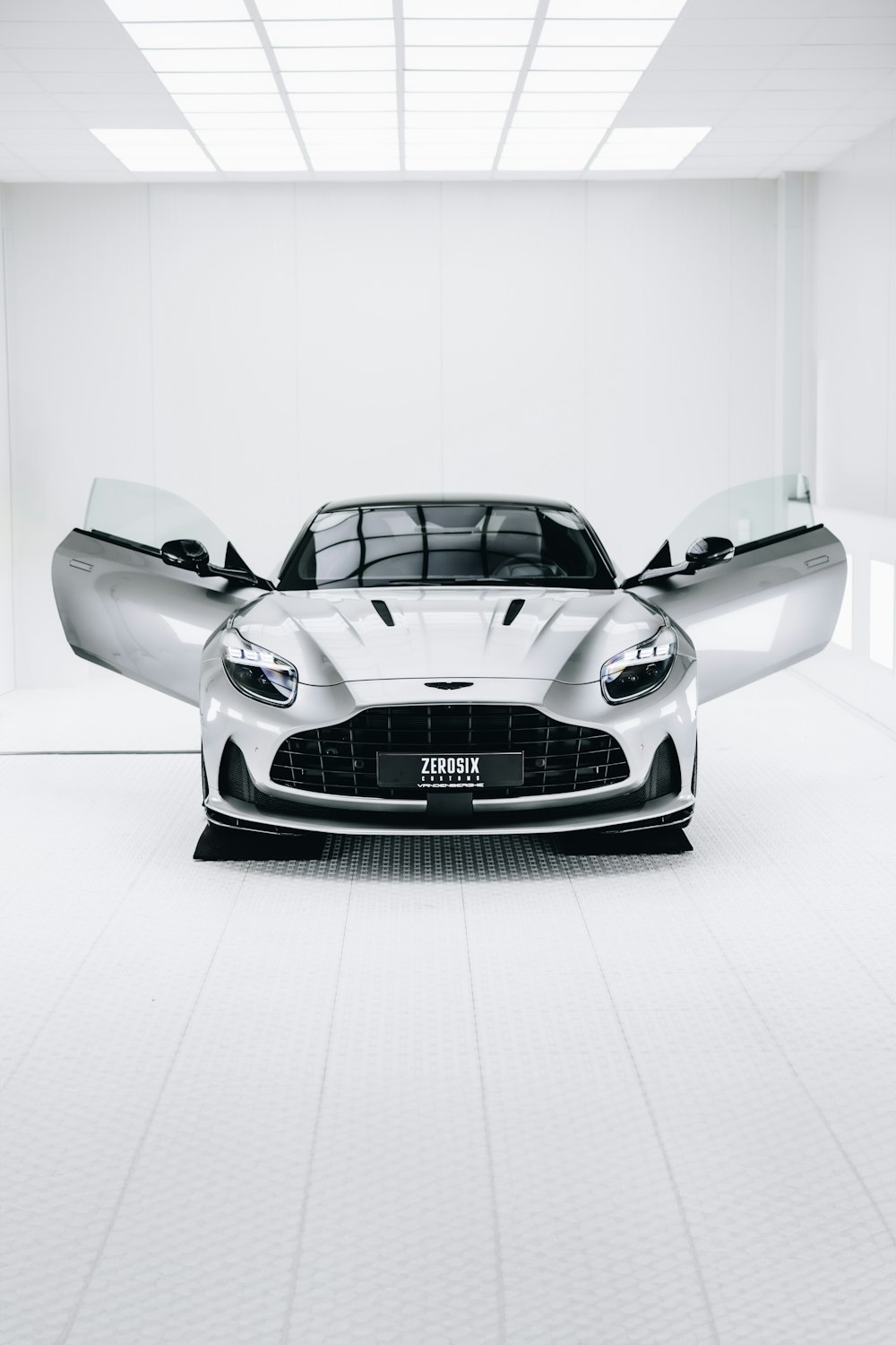 a silver sports car parked in a white room