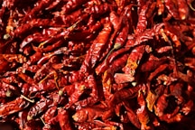 a pile of red peppers sitting on top of a table