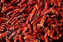 a pile of red peppers sitting on top of a table