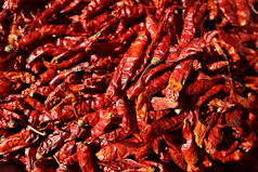 a pile of red peppers sitting on top of a table