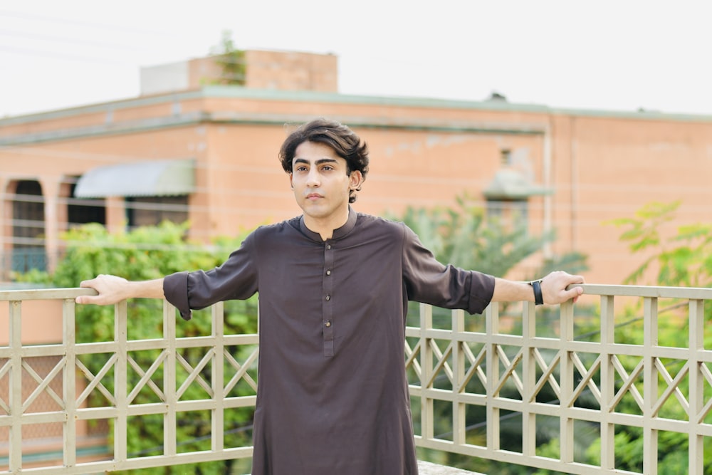 a man standing on a bridge with his arms outstretched