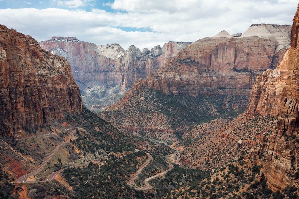 a scenic view of a mountain valley with a winding road