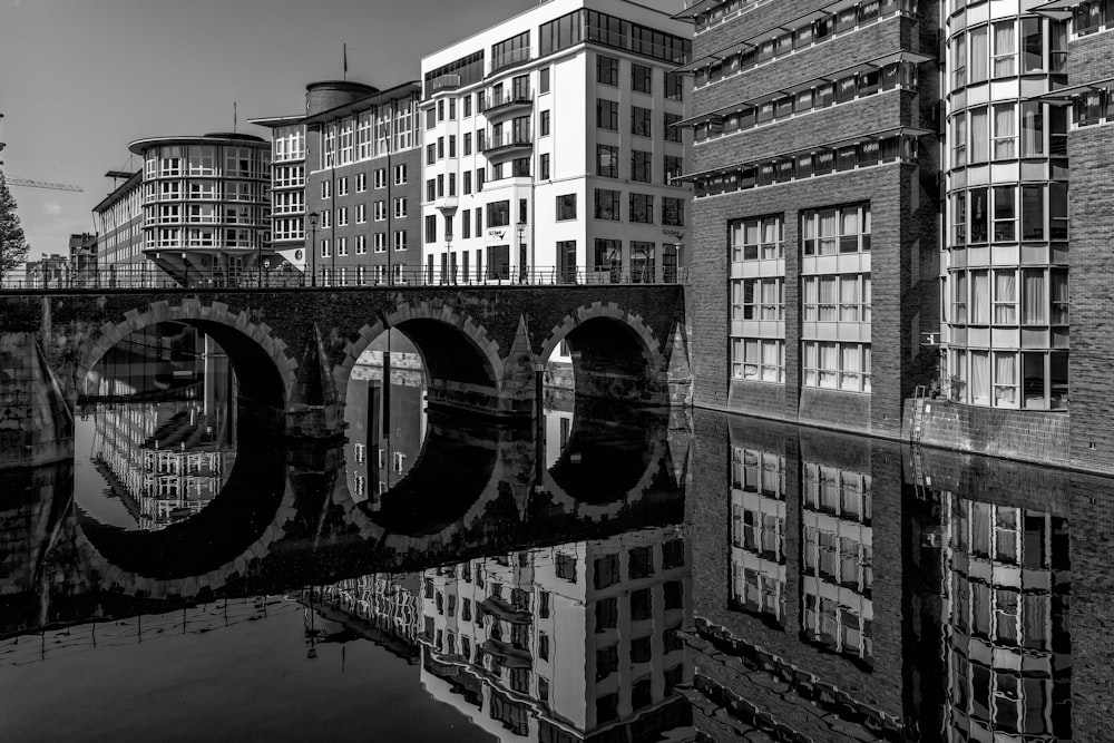 a black and white photo of a bridge and buildings