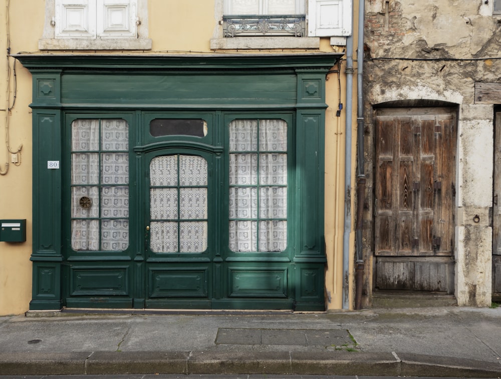 un vecchio edificio con una porta e una finestra verdi