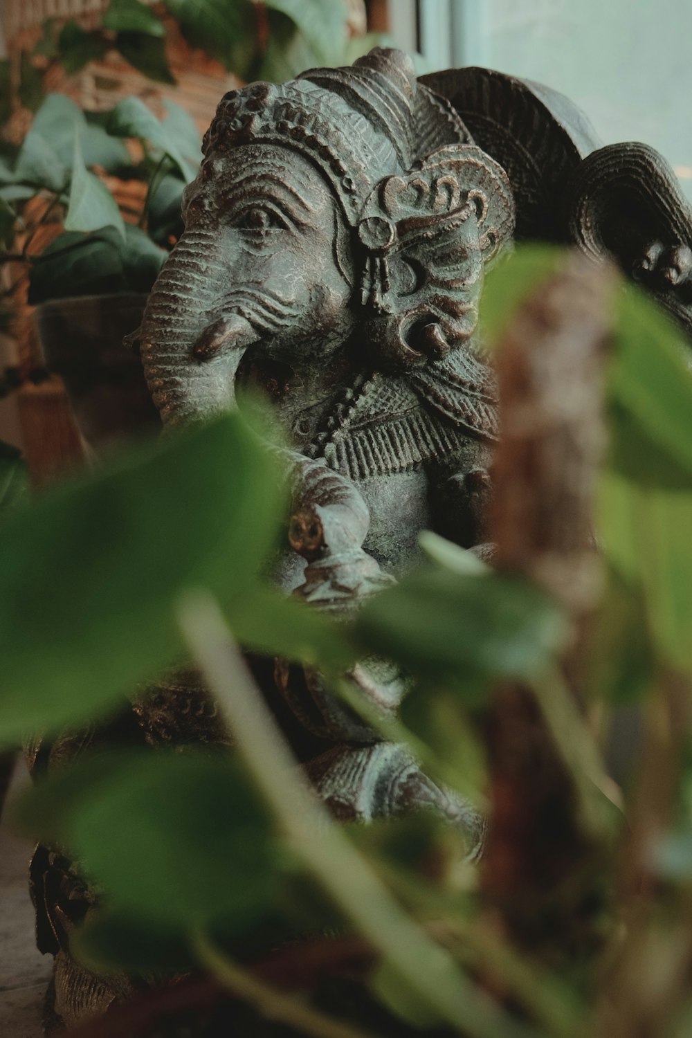 a statue of an elephant sitting next to a potted plant