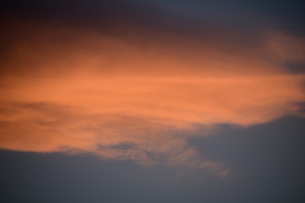 a plane flying in the sky at sunset