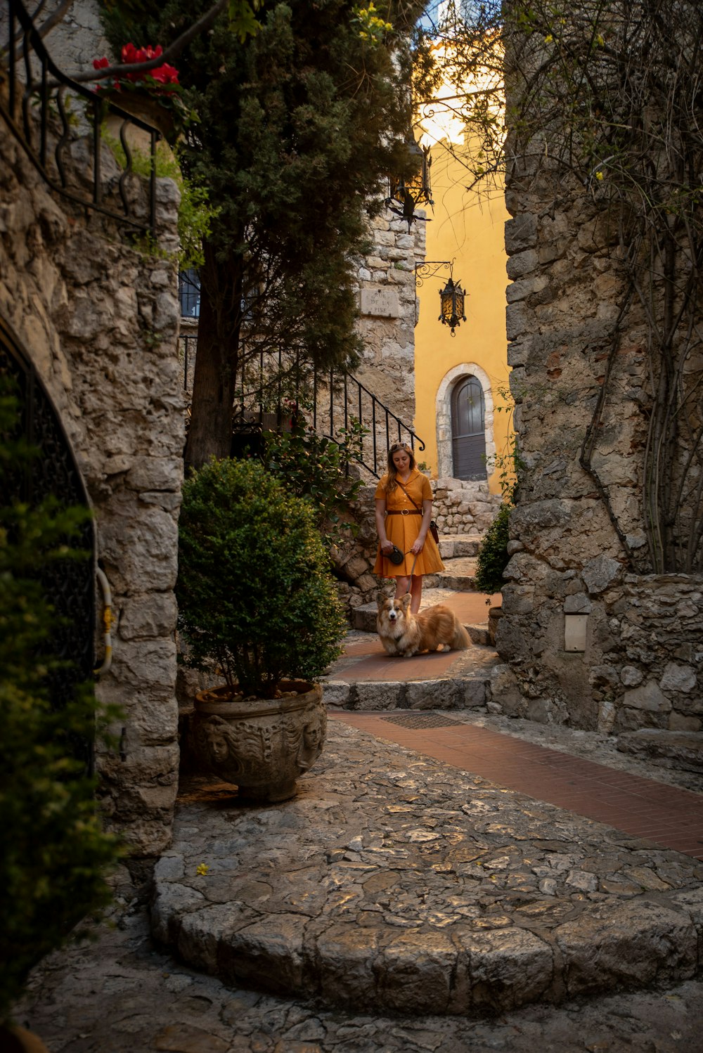 a woman is walking down a stone path