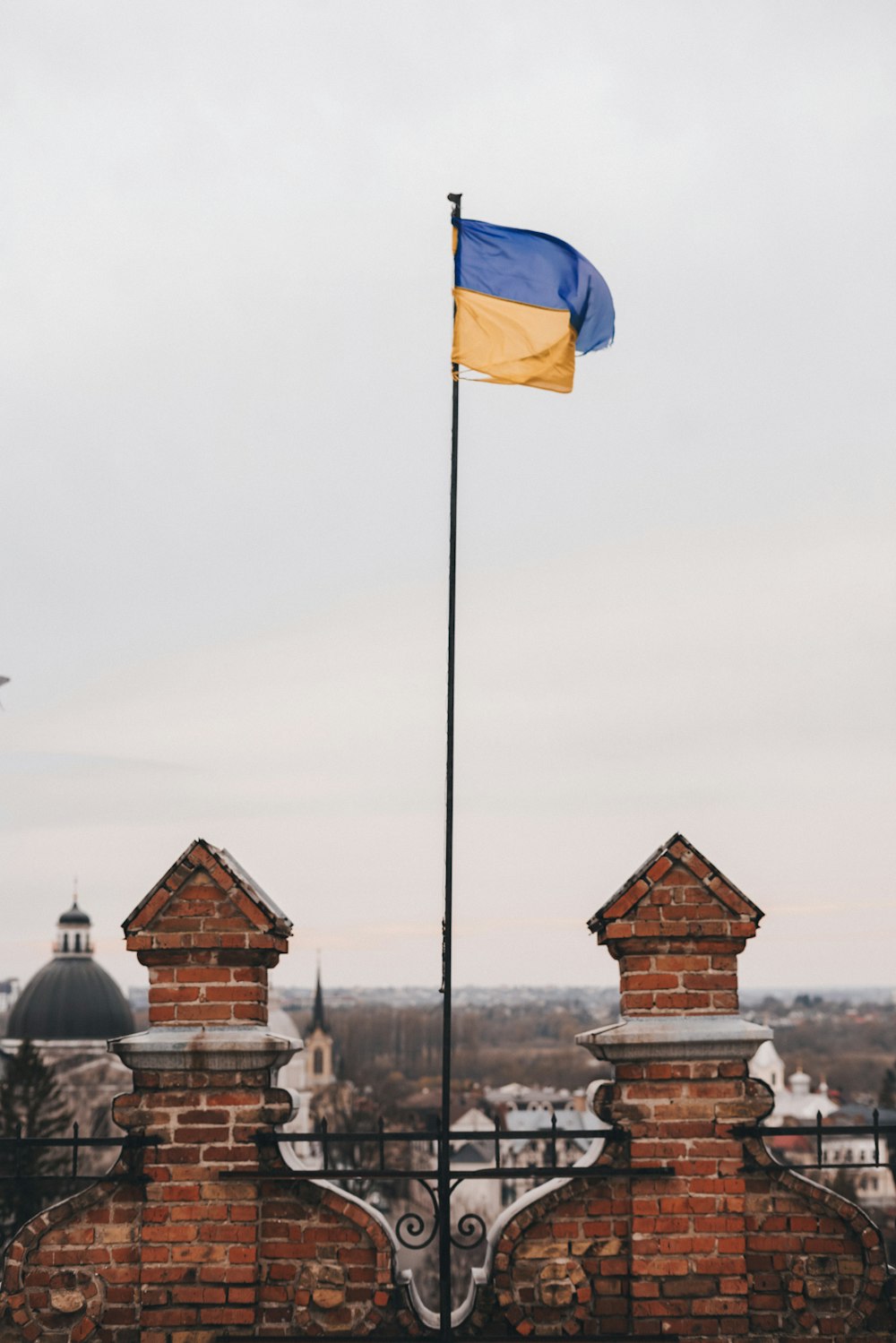 a flag on top of a brick fence