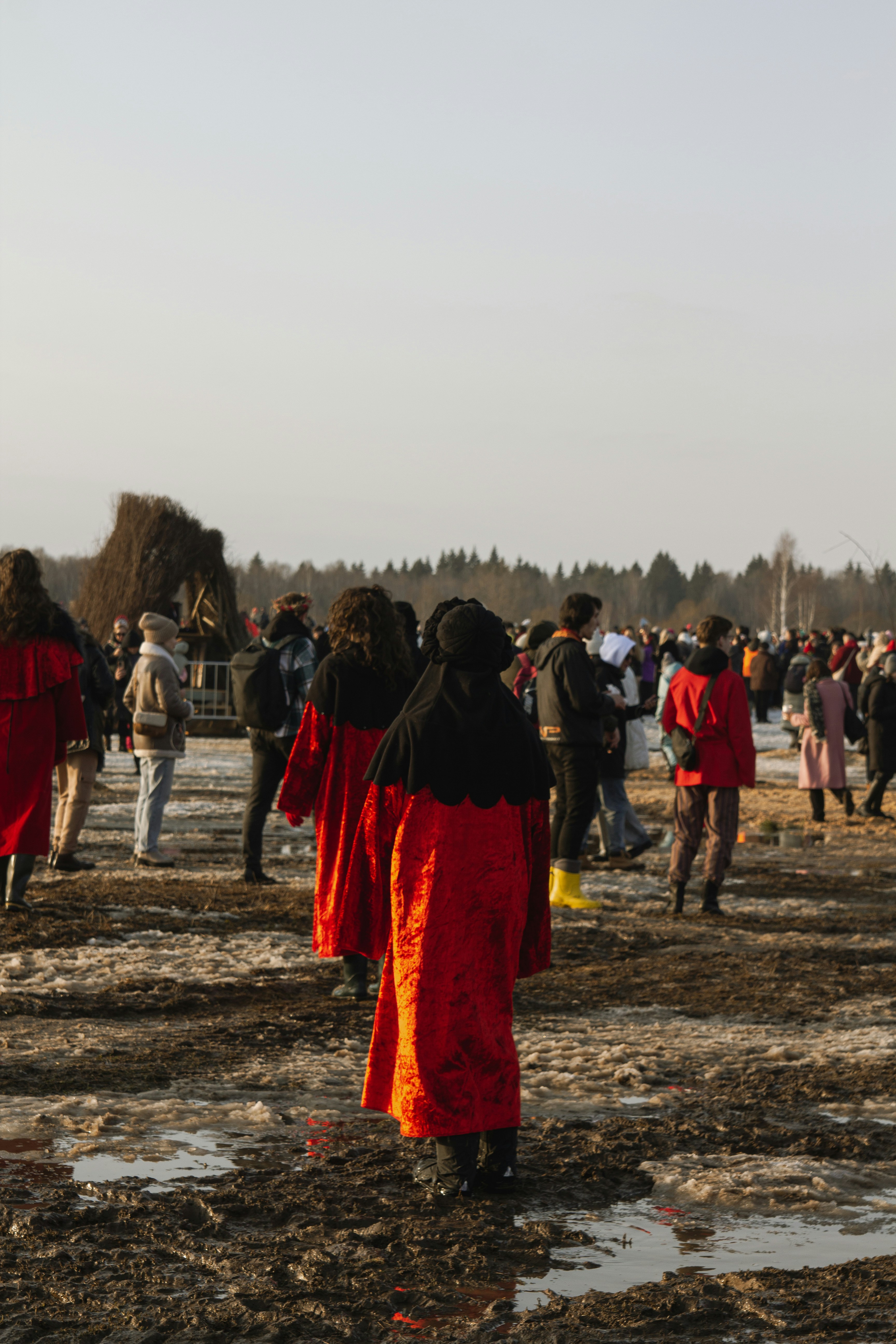a group of people standing on top of a muddy field