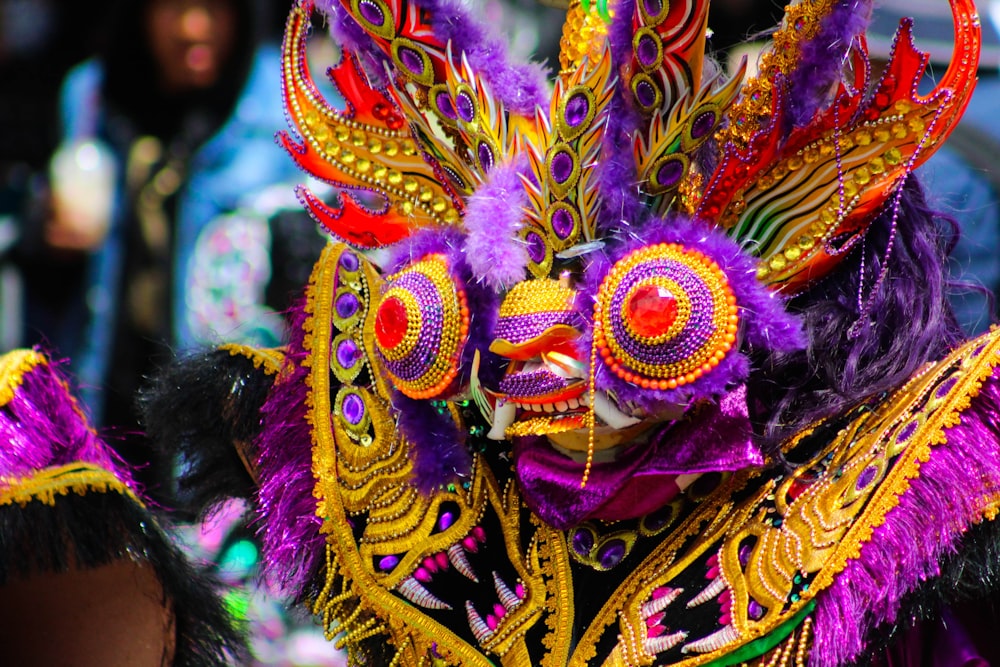a person wearing a colorful mask and headdress