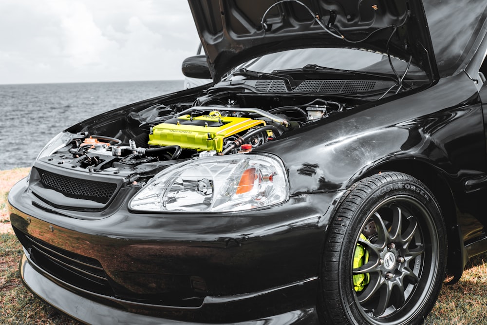 a car with its hood open and a yellow engine