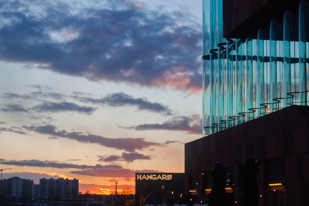 uma vista do pôr do sol de um edifício com uma placa nele