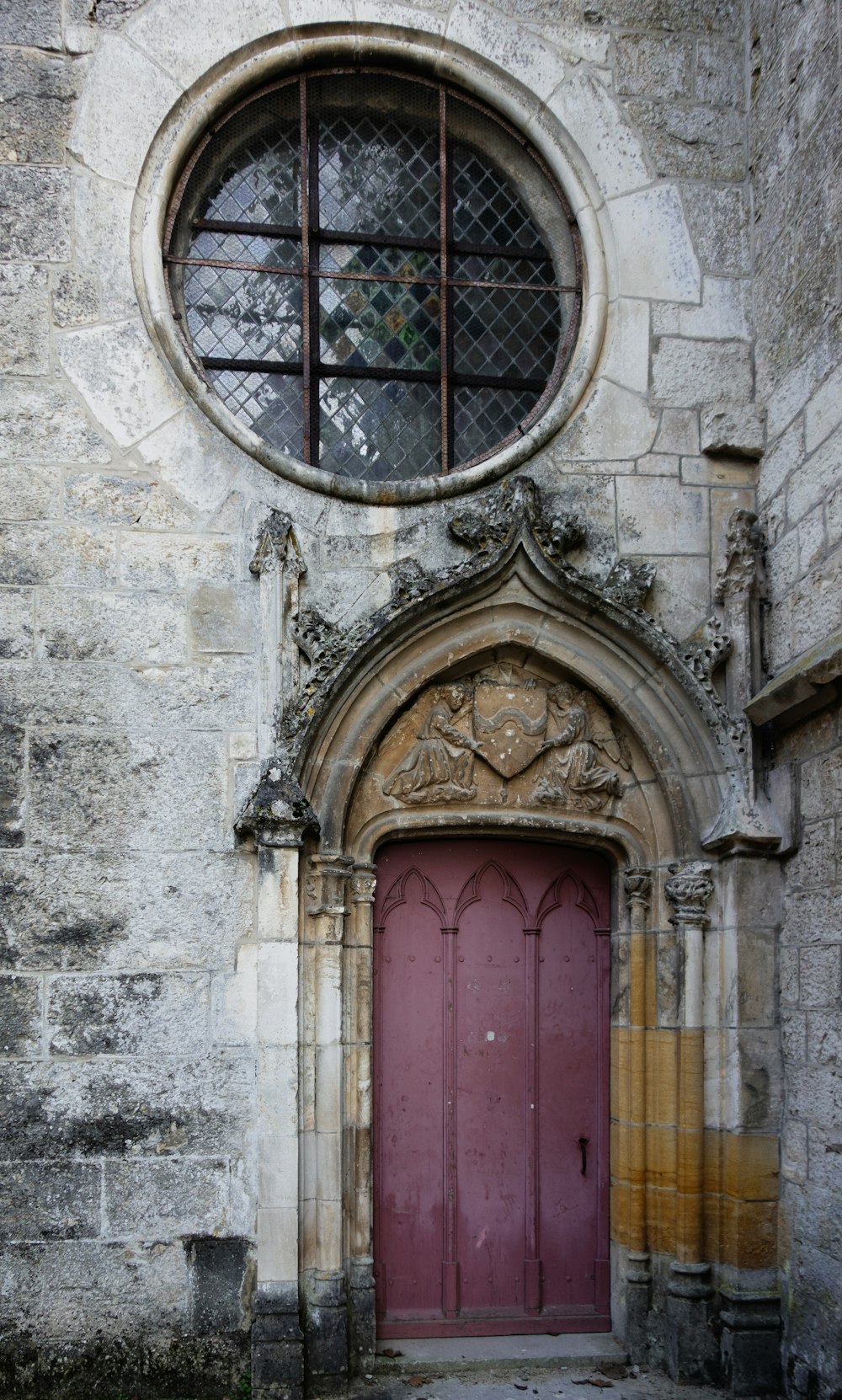 an old building with a red door and arched window