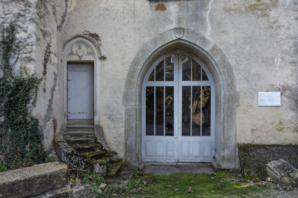 a white door and window in a stone building