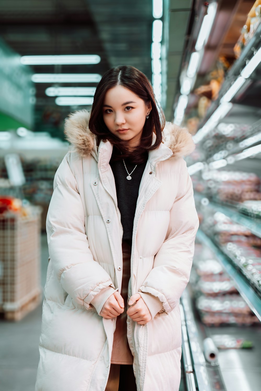 a woman is standing in a grocery store