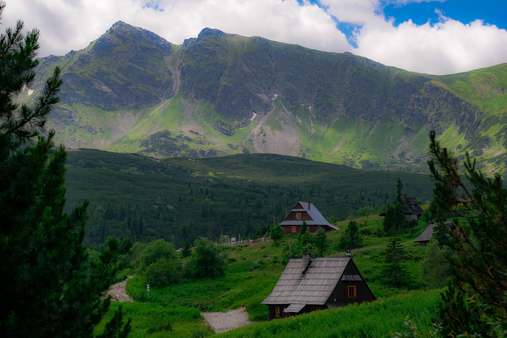 a house on a hill with mountains in the background