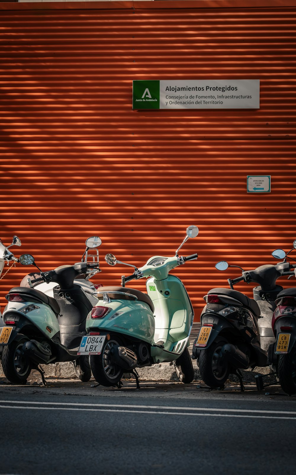 eine Reihe von Motorrollern, die vor einem Gebäude geparkt sind