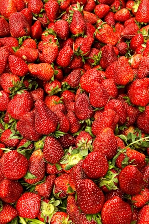 a large pile of strawberries sitting next to each other