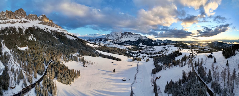 a snow covered ski slope with mountains in the background