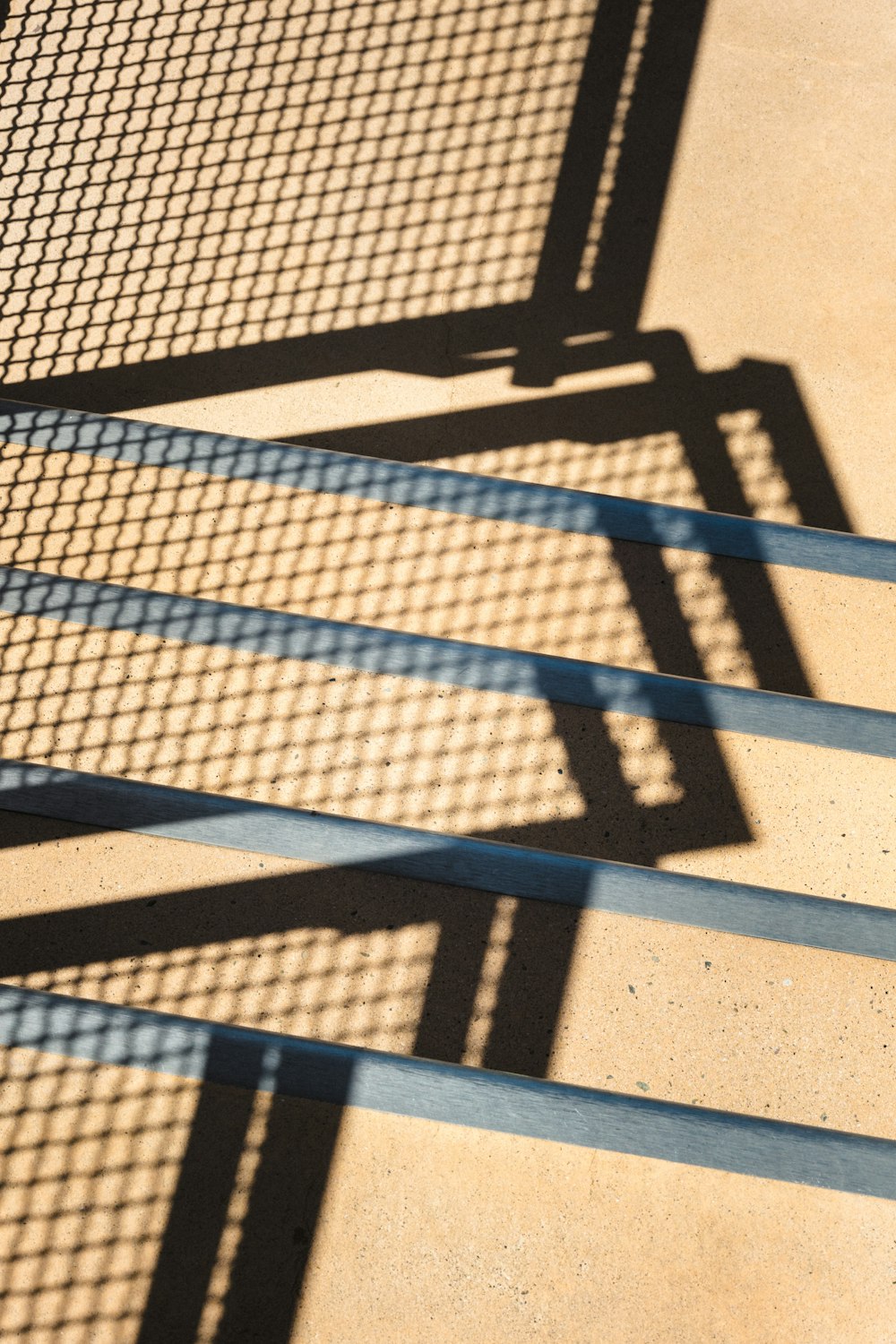 the shadow of a bench on the ground