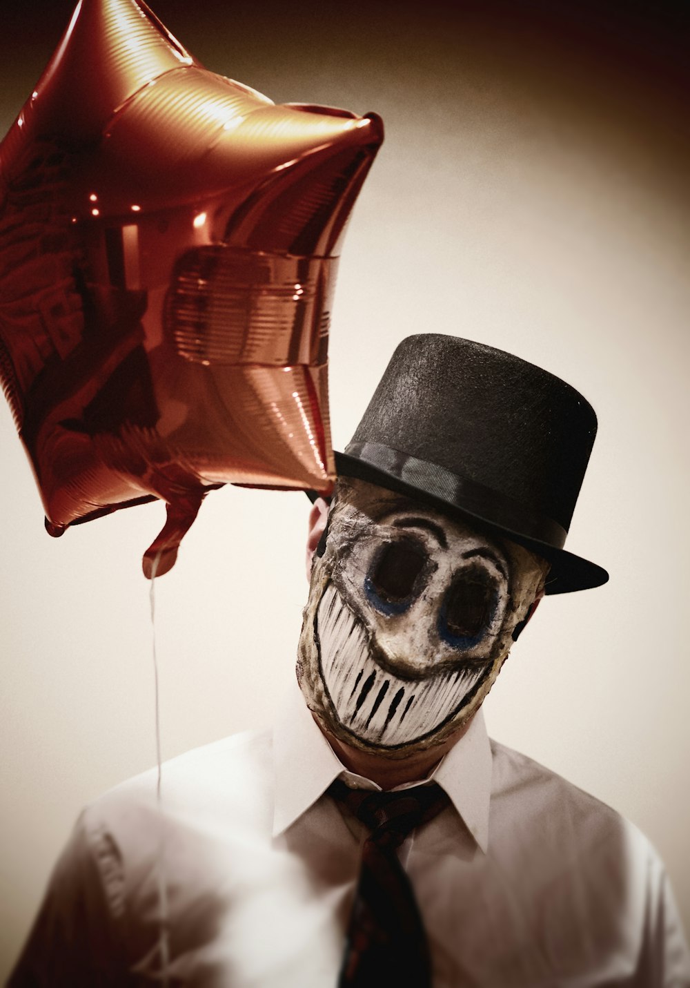 a man in a top hat holding a balloon