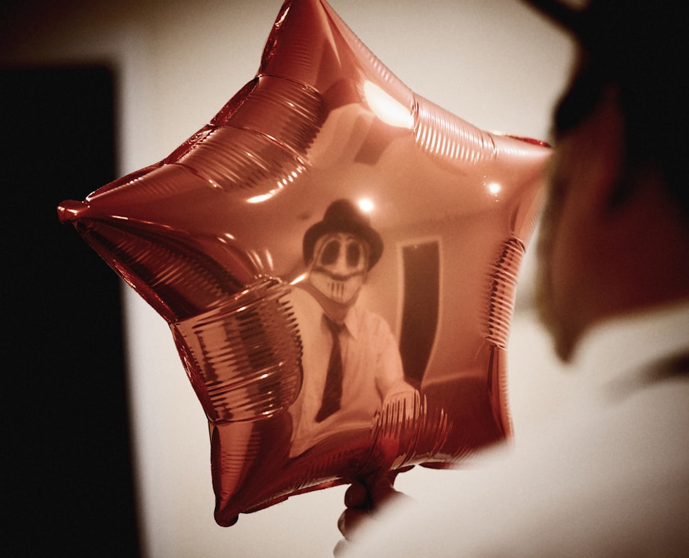 uma pessoa segurando um balão em forma de estrela com uma imagem nele