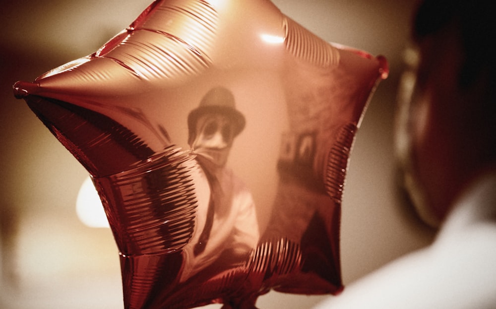 a person holding a red balloon with a picture on it