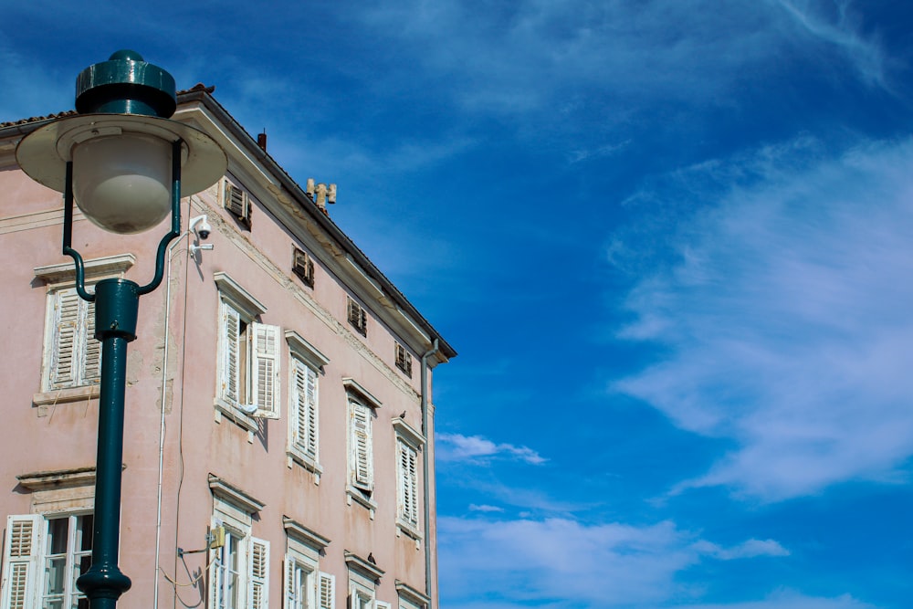 a street light in front of a pink building