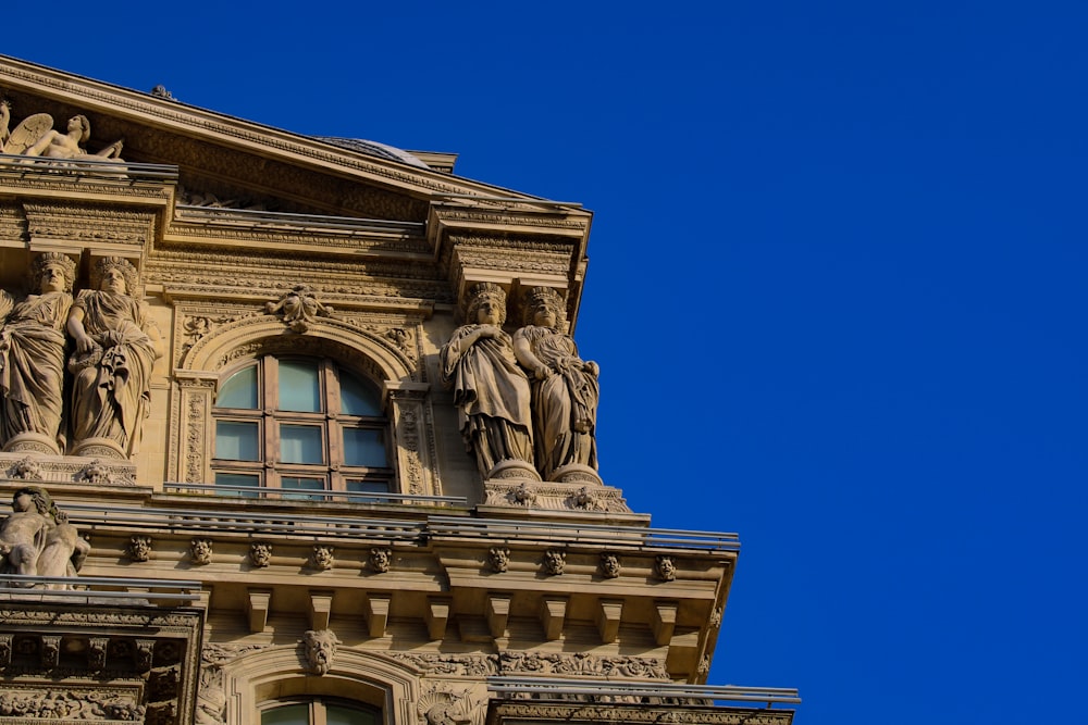 a tall building with statues on the top of it