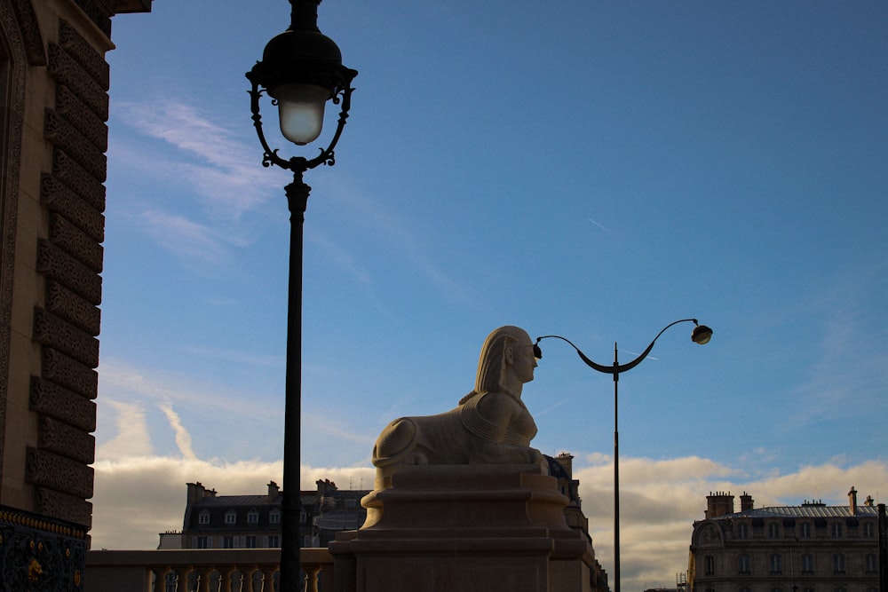 a lamp post with a statue on top of it