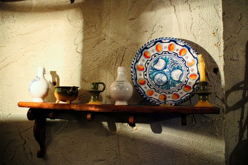 a shelf with vases and a plate on it