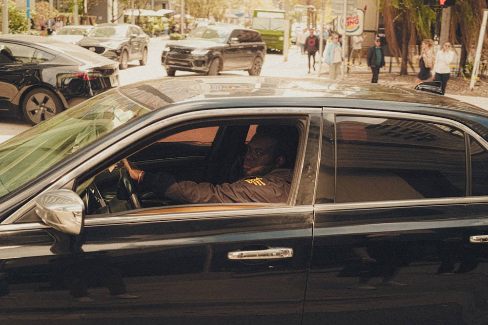 un uomo seduto in un'auto in una strada cittadina